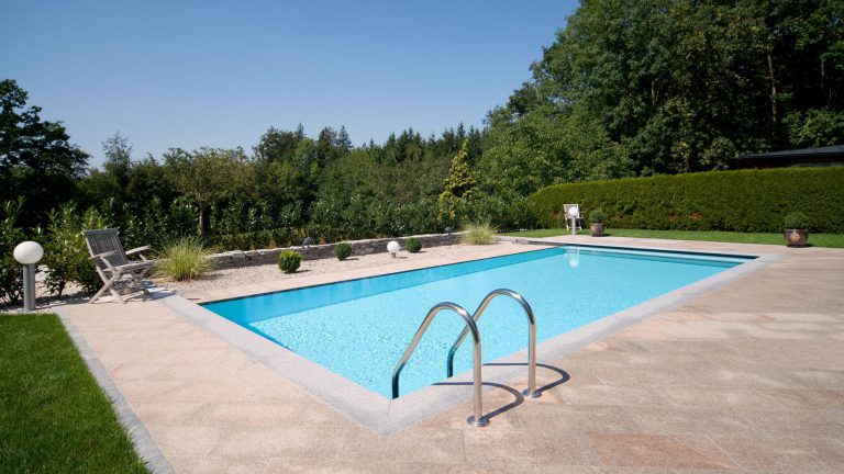 Poolrand-Gestaltung inkl. Vertikalstein bei Rechteckpool mit Überlauf und hellblauer Poolfolie - Happy-Pool
