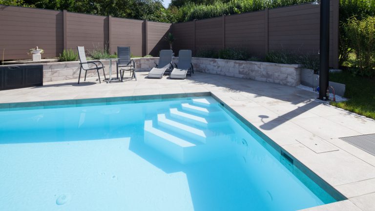 Poolrand-Gestaltung inkl. Vertikalstein bei Rechteckpool mit Ecktreppe und weißer Poolfolie - Happy-Pool".
