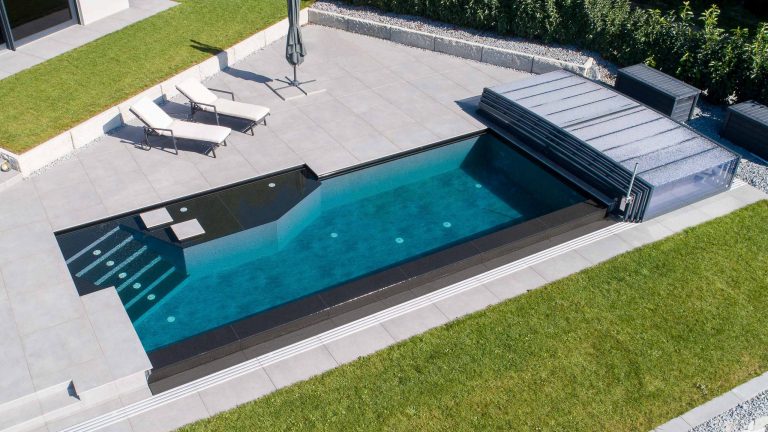 Pool mit Touchfolie am Boden, Folie dunkelgrau an den Wänden, Treppe und Überlauf mit Natursteinverkleidung