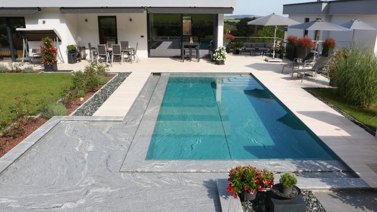 Rechteckpool mit Natursteinverkleidung und Einbautreppe
