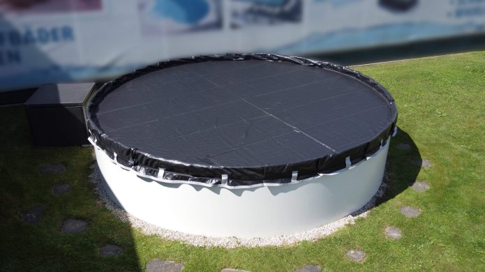 Schwarzes Winternetz schützt rundes Schwimmbecken